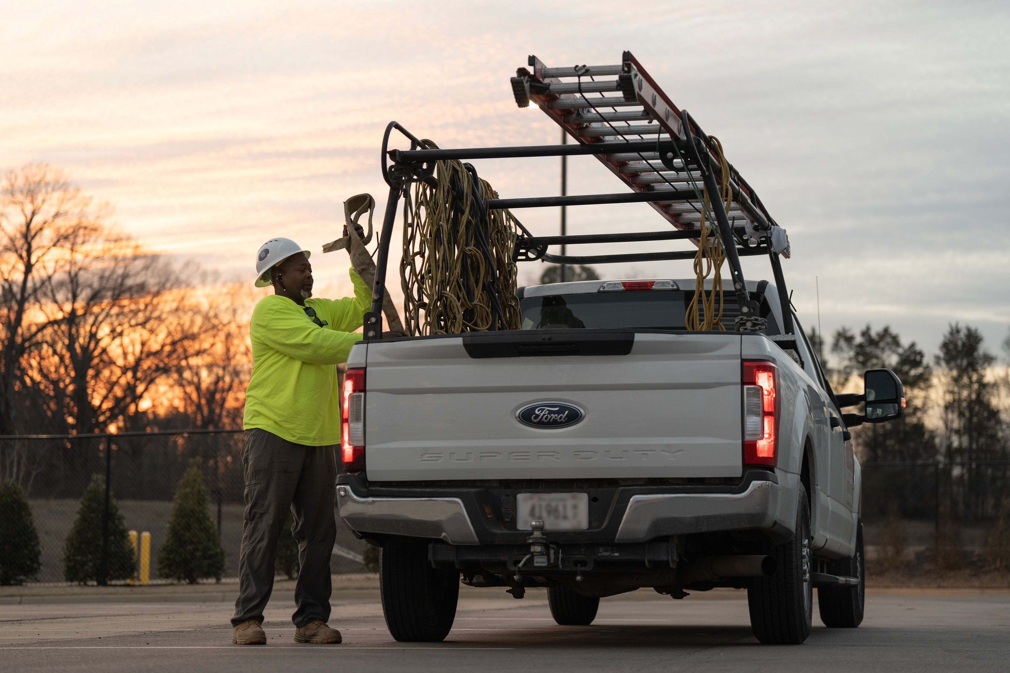 A worker loads equipment into a Super Duty truck.